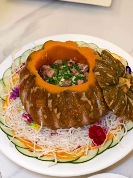 豉椒蒸排骨以整顆南瓜作為盛器，排骨吸收豉椒醬香與南瓜自然甜味，鹹香與甘甜相互交融，展現粵菜細膩火候與創意擺盤。圖／周含鍾攝