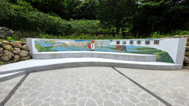 《圖說》「新北市石門區嵩山社區梯田環境改善工程」-結合在地文化意象設置牆面,展現社區故事與農村特色。〈農業局提供〉